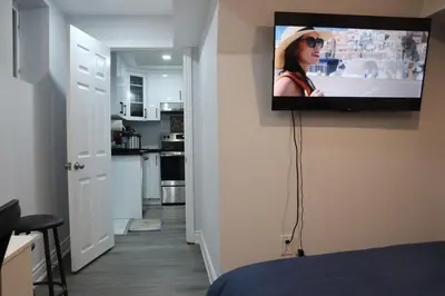 a flat screen tv hanging on a wall in a room at Garden 2 BR Apt - Free Parking Wifi Laundry Workstation in Brampton