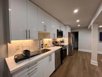 a kitchen with white cabinets and a sink at 2 Bedroom 1 Parking Basement Unit in Richmond Hill