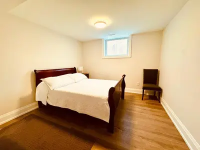 a small bedroom with a bed and a chair at 2 Bedroom 1 Parking Basement Unit in Richmond Hill