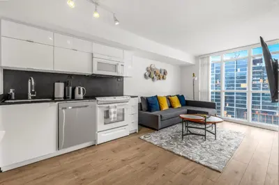 a kitchen and living room with a couch and a table at Beautiful 2 Bedroom Downtown Toronto Condo with free parking in Toronto
