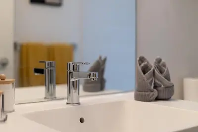 a bathroom sink with a faucet in front of a mirror at Beautiful 2 Bedroom Downtown Toronto Condo with free parking in Toronto