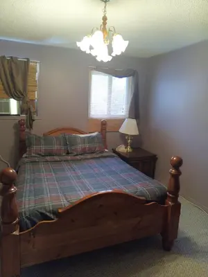 a bedroom with a bed and a chandelier at Princess Motel in Bobcaygeon