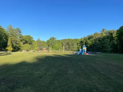 a large park with a playground with a slide at Muskoka Waterfront Cottage - Moon River with HOT TUB in Bala
