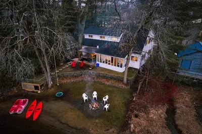 an aerial view of a house with people standing around a fire at Muskoka Waterfront Cottage - Moon River with HOT TUB in Bala