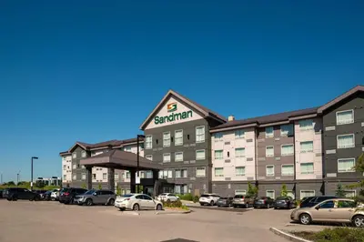 a large hotel with cars parked in a parking lot at Sandman Hotel Oakville in Oakville