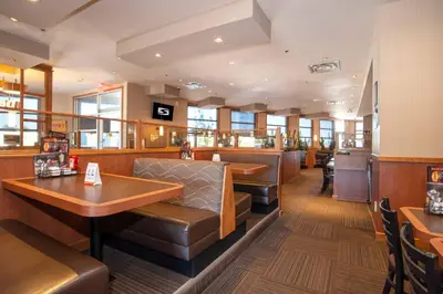 a restaurant with a bar with leather seats and tables at Sandman Hotel Oakville in Oakville