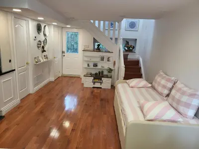 a living room with a couch and a staircase at Downtown Toronto House Central 2BED 2BATH Subway Free Parking in Toronto