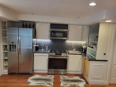 a kitchen with stainless steel appliances and white cabinets at Downtown Toronto House Central 2BED 2BATH Subway Free Parking in Toronto