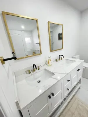 a white bathroom with two sinks and a mirror at Elegant & Luxurious 3 Bedroom Home in Mississauga