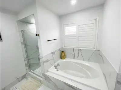 a white bathroom with a tub and a window at Elegant & Luxurious 3 Bedroom Home in Mississauga