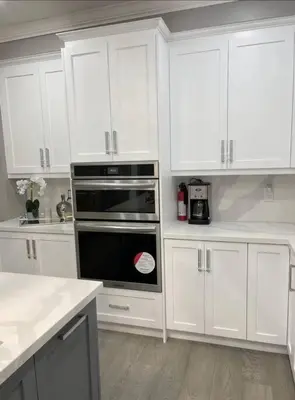 a kitchen with white cabinets and a black oven at Elegant & Luxurious 3 Bedroom Home in Mississauga
