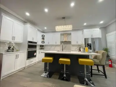 a kitchen with white cabinets and yellow bar stools at Elegant & Luxurious 3 Bedroom Home in Mississauga