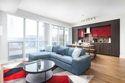 a living room with a blue couch and a table at Perfect Condo Sleeps 4 Across from Cn Tower! in Toronto