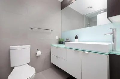 a white bathroom with a toilet and a sink at Perfect Condo Sleeps 4 Across from Cn Tower! in Toronto