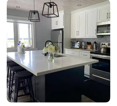 a kitchen with white cabinets and a white counter top at Sunrise net cottage in Kawartha Lakes