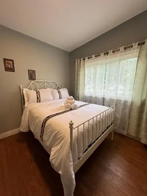 a bedroom with a white bed with a window at Lina's Place1 in St. Catharines