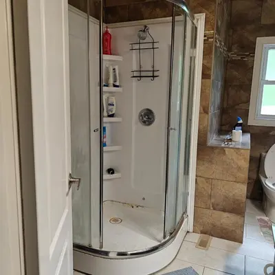 a shower with a glass door in a bathroom at Lina's Place1 in St. Catharines
