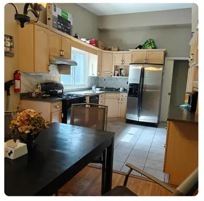 a kitchen with a table and a refrigerator at Lina's Place1 in St. Catharines