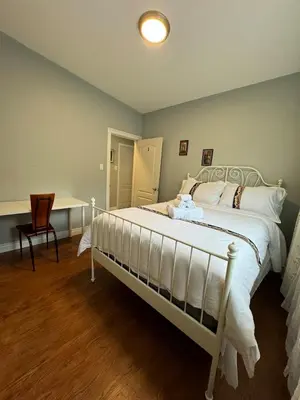 a bedroom with a bed with a desk and a chair at Lina's Place1 in St. Catharines
