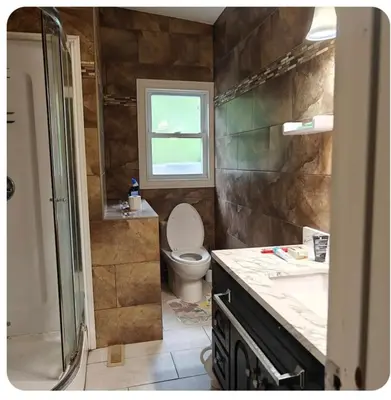 a bathroom with a toilet and a sink and a window at Lina's Place1 in St. Catharines
