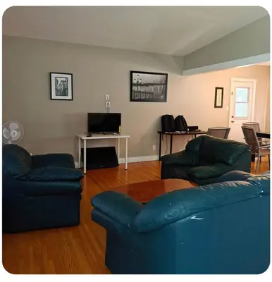a living room with two blue couches and a table at Lina's Place1 in St. Catharines