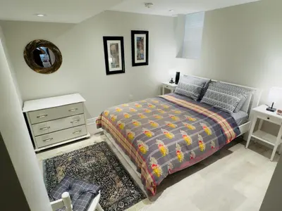 a bedroom with a bed and a dresser and a mirror at Spacious Basement in Oakville in Oakville