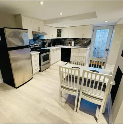 a kitchen with a refrigerator and a table and chairs at Spacious Basement in Oakville in Oakville