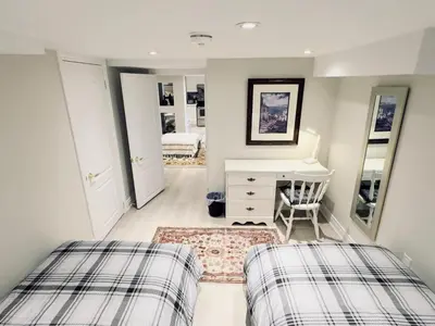 a bedroom with two beds and a desk and mirror at Spacious Basement in Oakville in Oakville