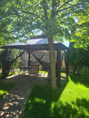 a gazebo with a table and chairs under a tree at Maya Bed and Breakfast in Port Perry