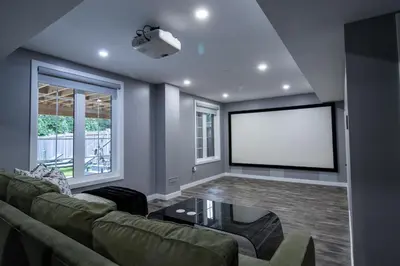 a living room with a couch and a screen at The Gate Chic & Cozy Basement Retreat in Ajax in Ajax