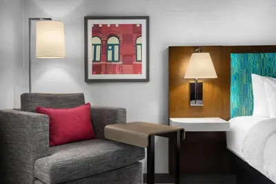 a living room with a chair and a bed at Hampton Inn & Suites Orangeville, On in Orangeville