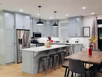 a kitchen with white cabinets and a table with chairs at Luxury Home 2 mins drive to Saugeen Shores beach in Port Elgin