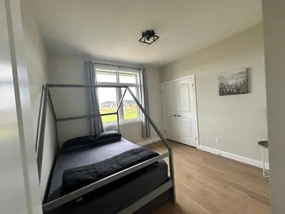 a bedroom with a bunk bed and a window at Luxury Home 2 mins drive to Saugeen Shores beach in Port Elgin