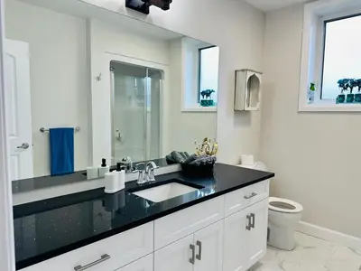 a white bathroom with a sink and a toilet at Luxury Home 2 mins drive to Saugeen Shores beach in Port Elgin
