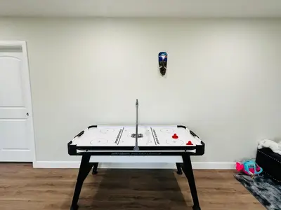a ping pong table in front of a white wall at Luxury Home 2 mins drive to Saugeen Shores beach in Port Elgin