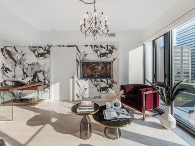 a living room with a chandelier and a couch at Hazelton Suites - Yorkville - Indoor Pool & Hot Tub in Toronto