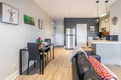 a living room and kitchen with a couch and a table at 1BR - Queen Bed Apartment in Hamilton's Best Neighborhood in Hamilton