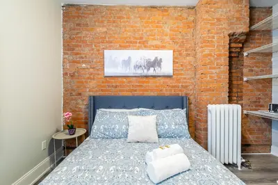 a bedroom with a brick wall and a bed at 1BR - Queen Bed Apartment in Hamilton's Best Neighborhood in Hamilton
