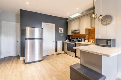 a large kitchen with a stainless steel refrigerator at 1BR - Queen Bed Apartment in Hamilton's Best Neighborhood in Hamilton