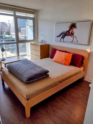 a bedroom with a bed with a horse painting on the wall at Downtown City View Escape with Free Parking in Toronto