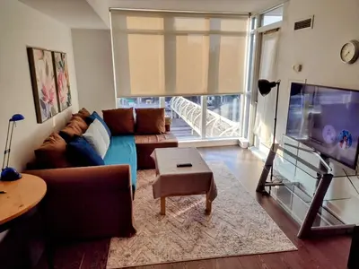 a living room with a couch and a tv at Downtown City View Escape with Free Parking in Toronto