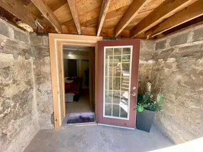 an open door in a room with a stone wall at Cobourg Country Home - 10 Minutes From Cobourg Beach! in Cobourg