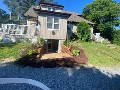 a house with a porch and a wooden deck at Cobourg Country Home - 10 Minutes From Cobourg Beach! in Cobourg
