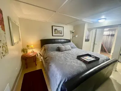 a bedroom with a bed with a black leather bed frame at Cobourg Country Home - 10 Minutes From Cobourg Beach! in Cobourg