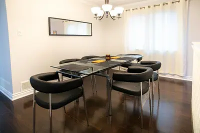 a dining room with a glass table and black chairs at Stunning Vacation Home North of Toronto in Richmond Hill
