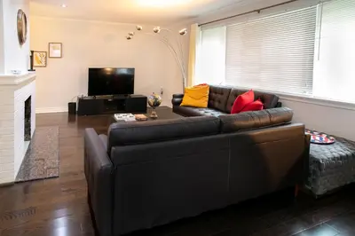 a living room with a leather couch and a television at Stunning Vacation Home North of Toronto in Richmond Hill