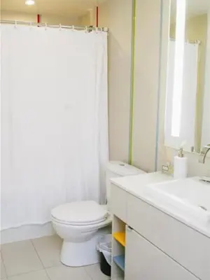 a white bathroom with a toilet and a sink at Bright 1BR w Large Terrace - Entertainment District in Toronto