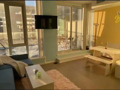 a living room with a couch and a table and windows at Bright 1BR w Large Terrace - Entertainment District in Toronto