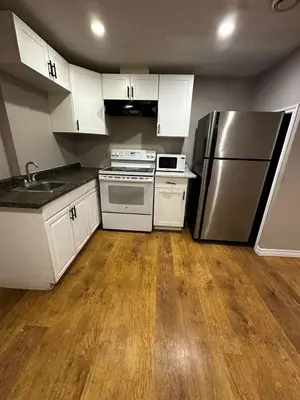 a kitchen with white cabinets and a stainless steel refrigerator at 3 Room Set for Up to 8 people- 10 minutes from Kitchener Airport, Walking to Transit in Kitchener