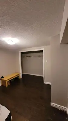 an empty room with a closet with a bench in it at 3 Room Set for Up to 8 people- 10 minutes from Kitchener Airport, Walking to Transit in Kitchener